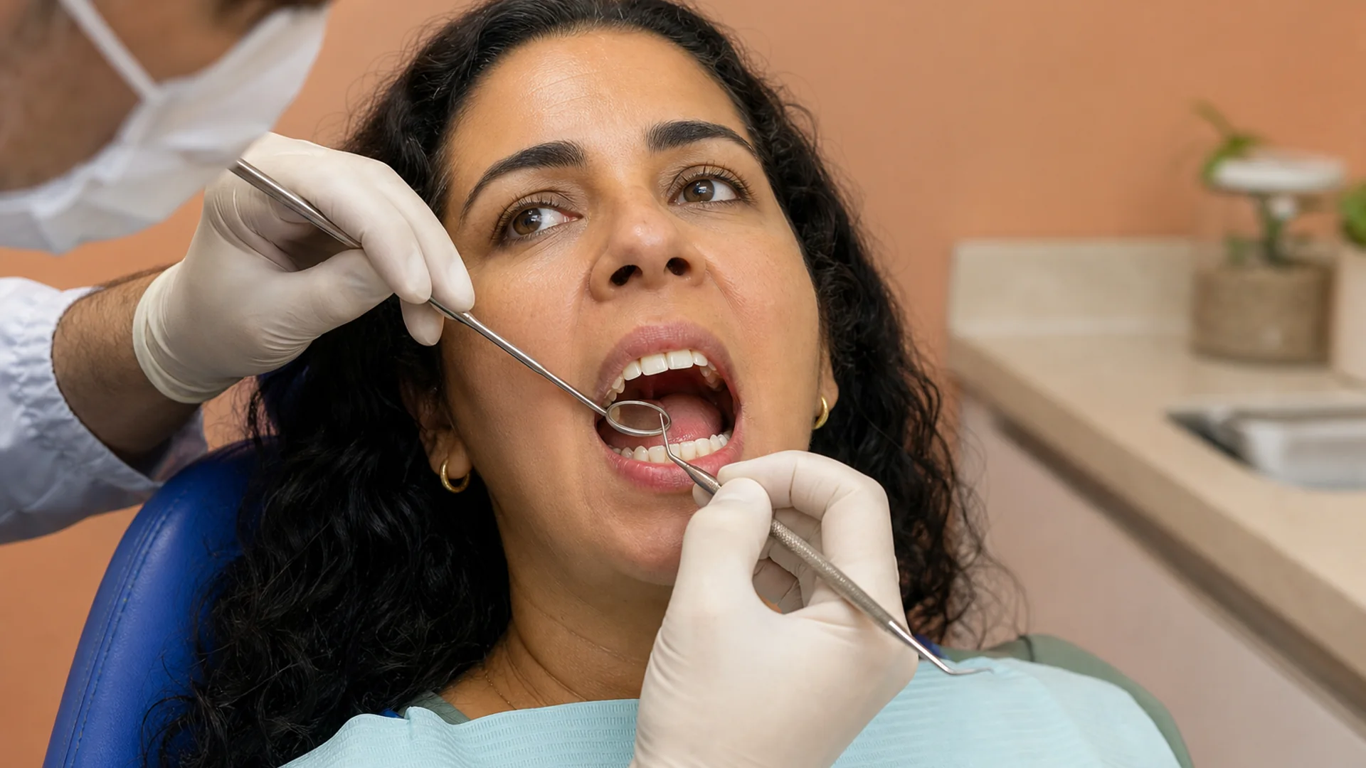 Dentista examinando gengiva e dentes na avaliação para profilaxia no Prado, Belo Horizonte