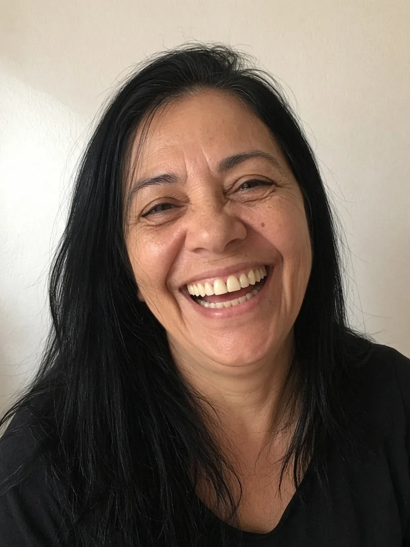 A mesma mulher rindo, com a arcada reabilitada. Dentistas BH, Prado, Belo Horizonte. Resultados individuais podem variar.